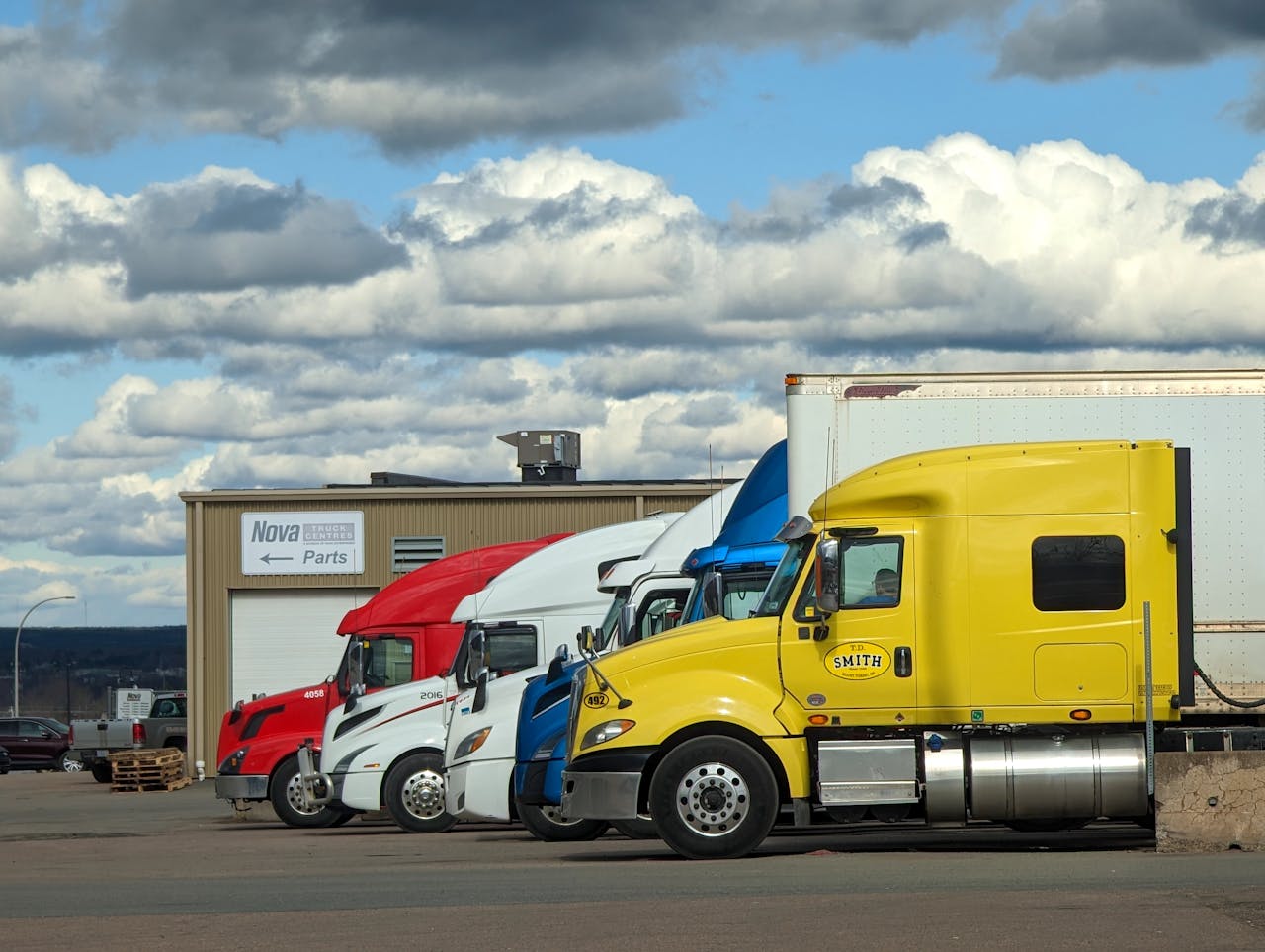 contact-img Parked semi-trucks of various colors outside a Nova Parts warehouse in Truro, NS.
